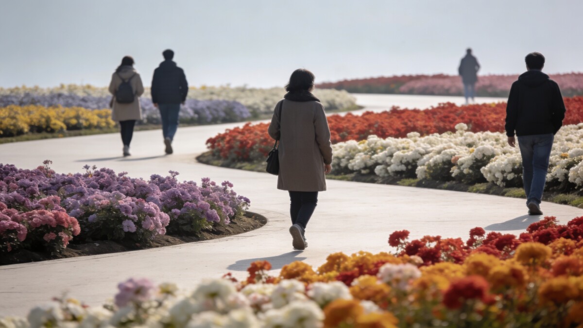 Promeneurs marchant entre massifs de fleurs colorees