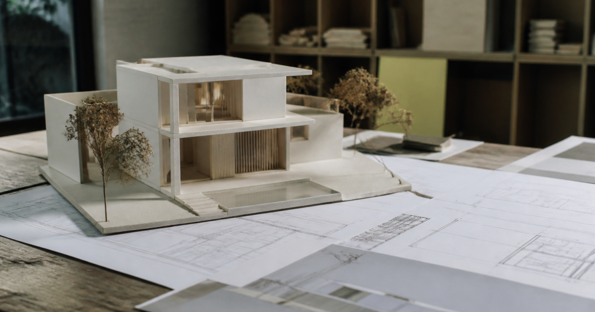 Maquette architecturale posee sur plans de construction detailles